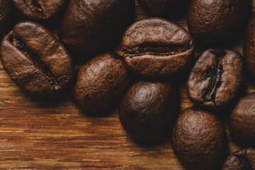 Coffee beans roasted on wooden background Close up macro copy space