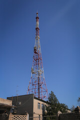 A telecomm tower phone network on hill with blue sky