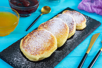 Delicious homemade syrniki with strawberry jam and honey. Traditional russian dish syrniki