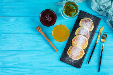 Delicious homemade syrniki with strawberry jam and honey. Traditional russian dish syrniki