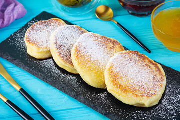 Delicious homemade syrniki with strawberry jam and honey. Traditional russian dish syrniki