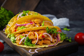 Mexican tacos with corn tortilla. Tortilla with chicken meat, corn, lettuce and onion