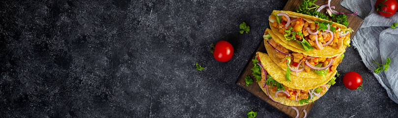 Mexican tacos with corn tortilla. Tortilla with chicken meat, corn, lettuce and onion. Top view