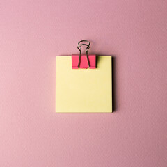 Sticky memo pad and metal clip isolated on pink background. top view, copy space