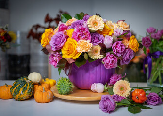 Fototapeta na wymiar Colored roses in purple vase