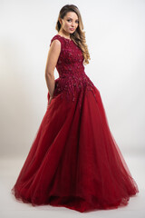 beautiful young blond woman in dress on white studio background