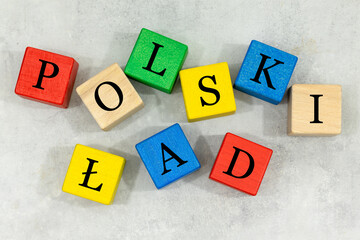 Scattered wooden blocks with the words Polski Ład (Polish language) Concept, introduction of a bug-free economic program in Poland, Reform of state finances