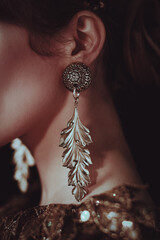 Close-up detail of a vintage gold earring in a woman's ear