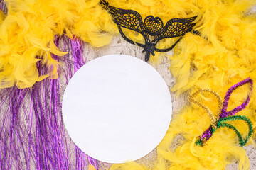 Mardi Gras Mockup, Wooden empty round sign template with mask and feather boa on golden background,...