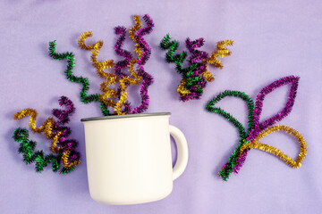 Mardi Gras Mockup, Empty blank white coffee mug on fabric lilac background. Mardi Gras party Mock...