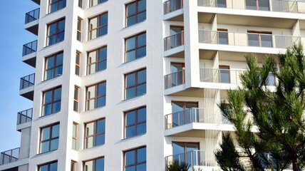 Modern luxury residential flat. Modern apartment building on a sunny day. White apartment building with a blue sky. Facade of a modern apartment building.