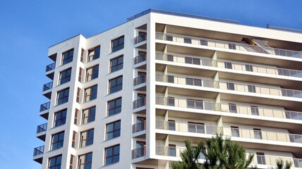 Modern luxury residential flat. Modern apartment building on a sunny day. White apartment building with a blue sky. Facade of a modern apartment building.