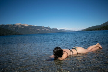 una mujer nadando en un lago descansando en vacaciones tomando sol