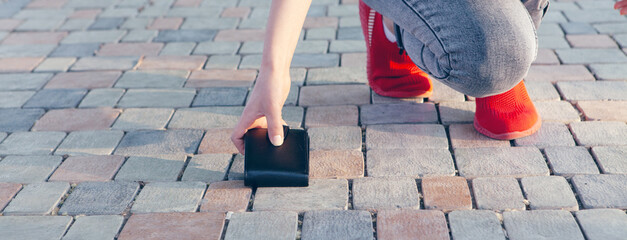 young woman picks up wallet