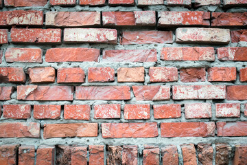 Background of red cracked weathered old wrecked uneven rough brick wall, pattern, grunge surface, texture