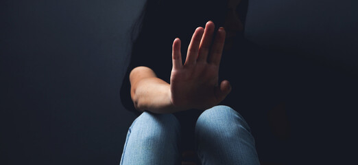 woman sitting on the floor covering her face sad