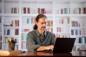 Angry stressed businessman reading bad news on laptop. Mad man feels frustrated about high bills, dismissal notice, bank debt, tax invoice or mistake sits at home office desk.