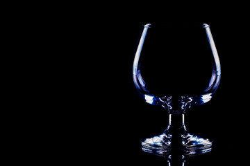copa de coñac - copa vacía aislada sobre fondo negro, espacio para texto