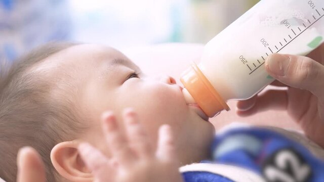 哺乳瓶からミルクを飲むアジア人の赤ちゃん