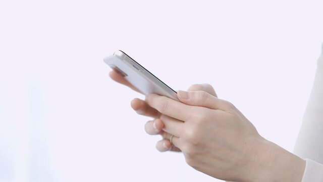 スマートフォンでテキスト入力をするアジア人の女性
