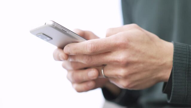 スマートフォンでテキスト入力をするアジア人の男性