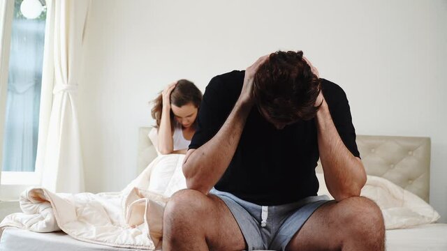 Trouble relationship couple married concept. Unhappy husband headache problem crisis something while his wife sitting together on the bed at home.