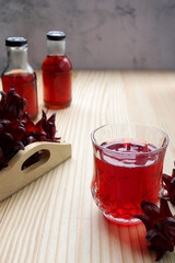 Cup of Roselle tea with Fresh roselle fruit ,Jamaica sorrel, Rozelle or hibiscus sabdariffa on wooden table. 