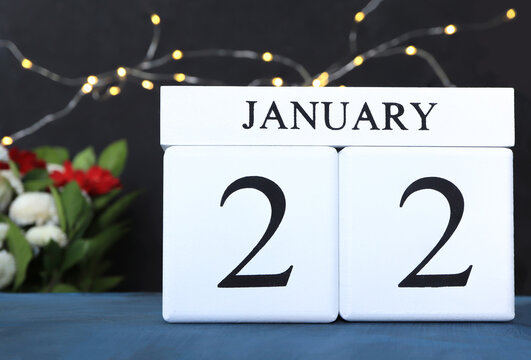 January 22nd, Wooden calendar showing date on 22 january on  bokeh lights background in the room.