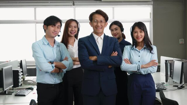 Businessman leader smiling in formal suit glasses standing smart with his arms crossed in an office workplace, portrait of happy young male boss manager or CEO look at camera