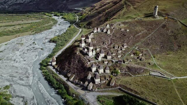 Aerial orbit North Ossetia unique Dargsvs city of dead. Many houses on top of rocky mountains, burial vault alpine crypt. Caucasus traditional historical culture village aul.