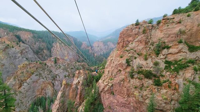 Raindrops Falling As A Woman Enjoys Ziplining At Seven Falls In Colorado Springs as a Tourist. wide