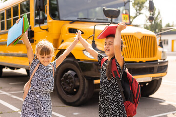 adorable schoolchildren running to school bus