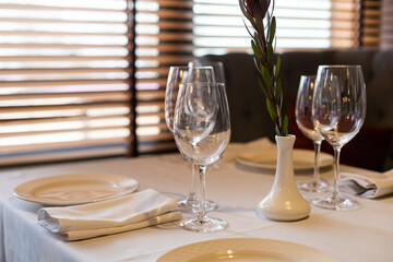 beautifully laid tables with glasses and appliances at morning in restaurant