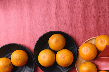Orange fruit and red packet on red background with copy space, Chinese New Year, Lunar New Year