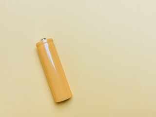 Rechargeable nicd AA size battery isolated on yellowish background.