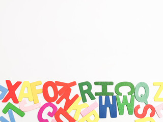 Colorful wooden alphabets against white background with copy space.