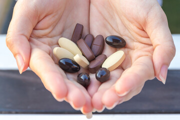 Selective focus to Multivitamin tablets on hand of women or girl.