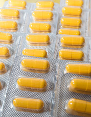 yellow capsules pills pills in a silver blister close-up