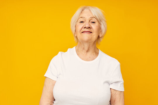 smiling elderly woman in casual t-shirt gestures with his hands close-up emotions