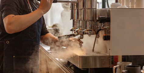 Barista is releasing steam from coffee machine