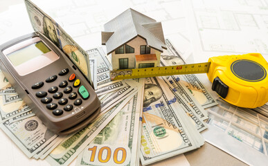 Fototapeta na wymiar Miniature model of house against the background of a house plan, and money, and calculator.