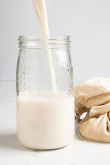 Nut milk being poured into a jar
