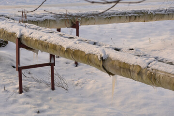 Damaged insulation of a city overhead heating line on concrete supports in a residential area of the city. Poor heat supply to the city in winter.
