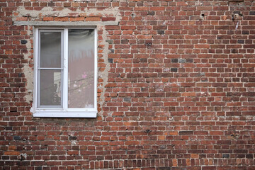 Front view of new plastic window exterior on old red brick wall