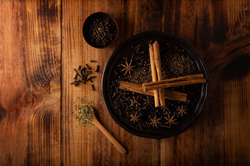 Various spices on wooden rustic board background. Pepper, cardamom, clove, cinnamon, star anis, dehydrated parsley..Flat lay
