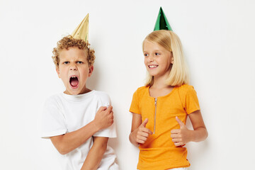 Cute stylish kids posing emotions holiday colorful caps isolated background unaltered