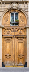 Fototapeta na wymiar Paris, an ancient wooden door, beautiful facade in the 11e arrondissement 