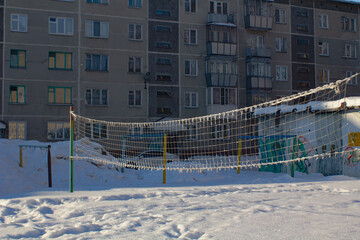 A playground in the courtyard for playing volleyball, covered with snow in winter.