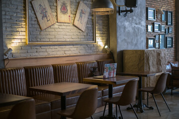 Laptop with stickers stands on a table in a coffee shop. Cafe design. Playing cards on the wall. High quality photo