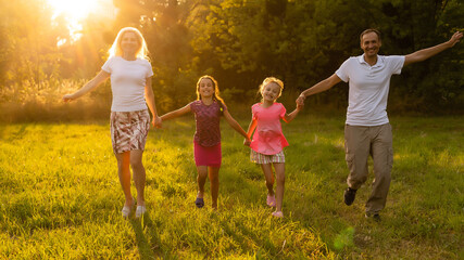 Plakat Happy family father of mother and children on nature at sunset